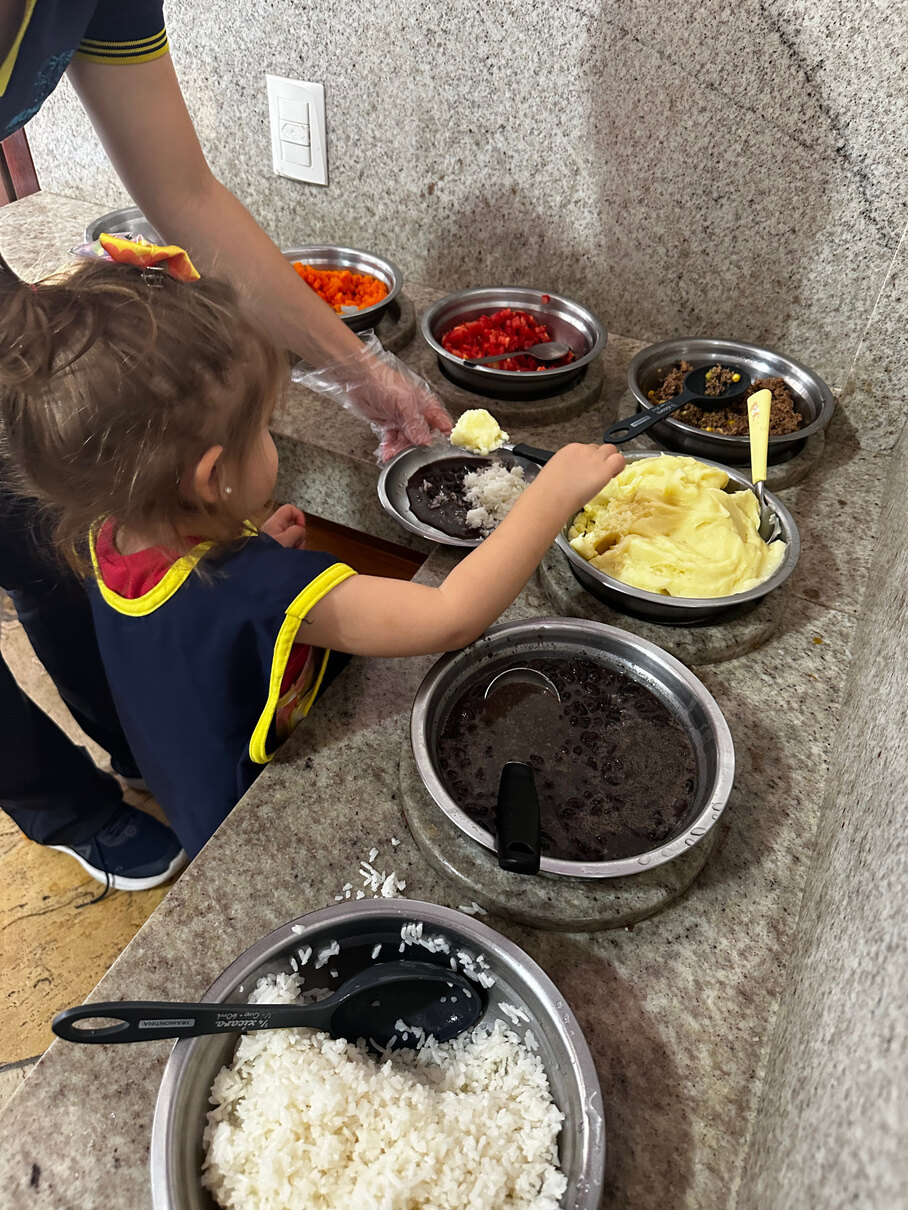 Criança participando de uma experiência de cozinha e vida prática