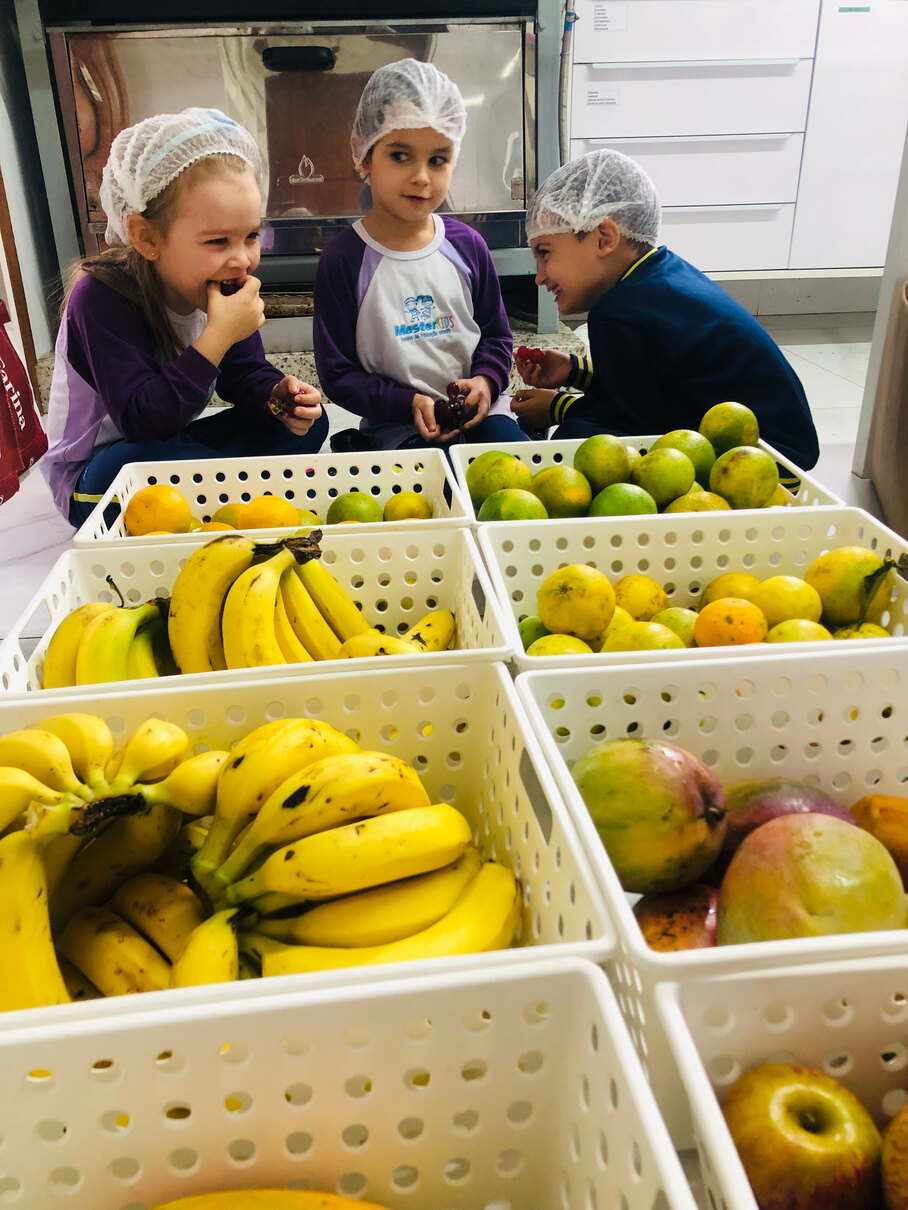 Crianças escolhendo frutas no buffet